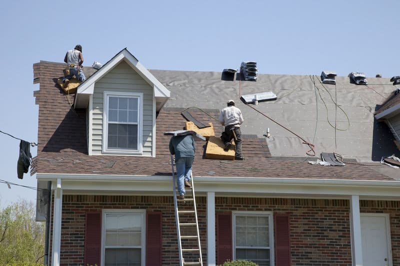 Roofing services crew installing asphalt shingles